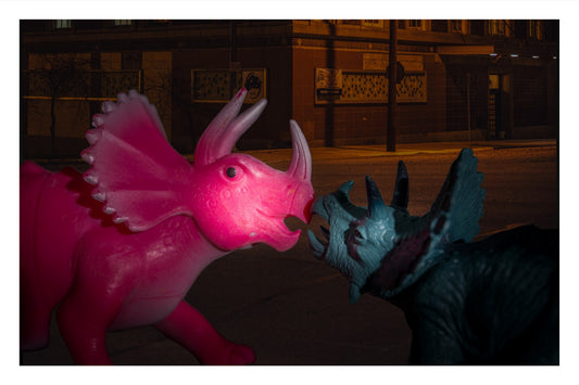 Color photo captured by paparazzi of two toy triceratops about to kiss outside a club.